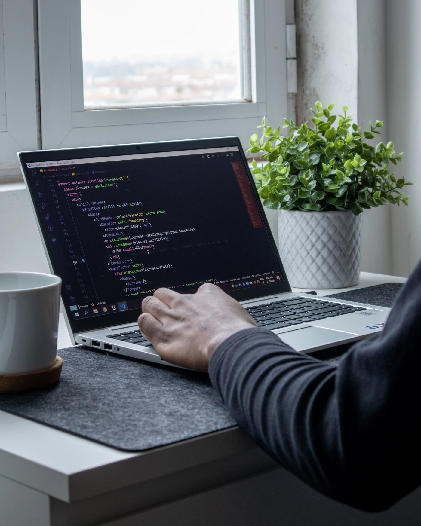 Representative real workspace with a developer writing code on a laptop